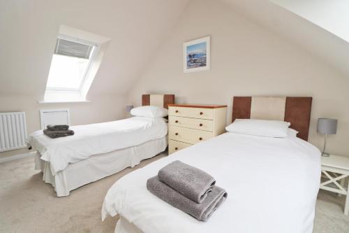 a bedroom with two beds and a window at BY THE BEACH cottage, dogs welcome in Saint Merryn