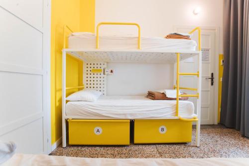 two bunk beds in a room with yellow walls at Ostello Bello Lake Como in Como