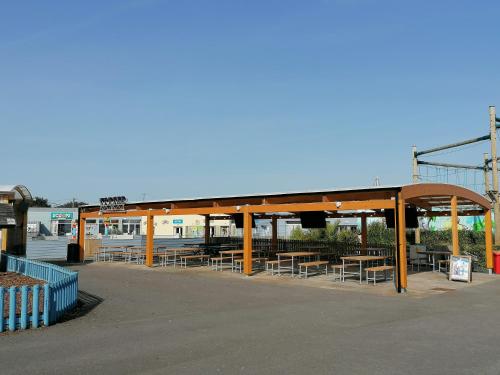 een bushalte met tafels en banken op een parkeerplaats bij Sycamores Caravan in Helston