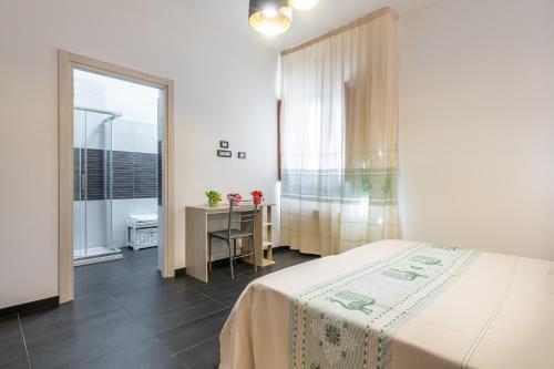 1 dormitorio con cama, mesa y ventana en AffittaSardegna-CASA LA VIGNA en Alguer