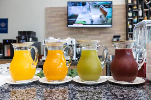three pitchers of juice on plates on a counter at Somerset Westview Nairobi in Nairobi