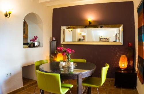 マルベーリャにあるIdyllic Townhouse in Marbella Old Townのダイニングルーム(テーブル、緑の椅子付)