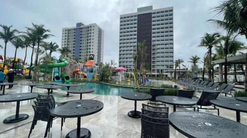 Salinas Premium Resort في سالينوبوليس: منتجع به طاولات وكراسي ومسبح