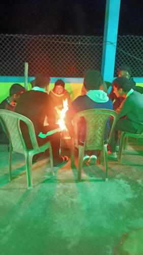 a group of people sitting around a fire at ANURAG HOMESTAY in Kurseong
