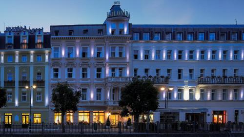 a large white building with lights on at Hotel Kolonada in Karlovy Vary
