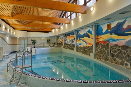 a pool in a hotel with a painting on the wall at Hotel Kolonada in Karlovy Vary