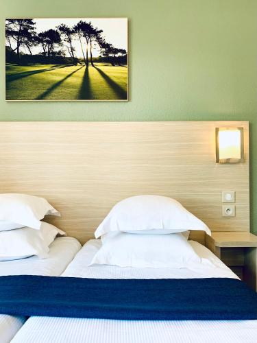 a bedroom with a bed with a picture on the wall at Hippotel in Le Touquet-Paris-Plage