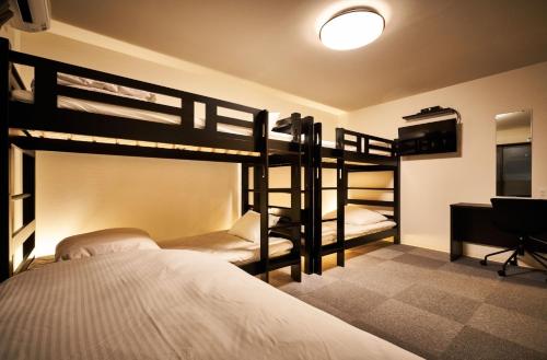 a bedroom with two bunk beds and a desk at Rikyuan Kyoto Nishikyogoku room C in Kyoto