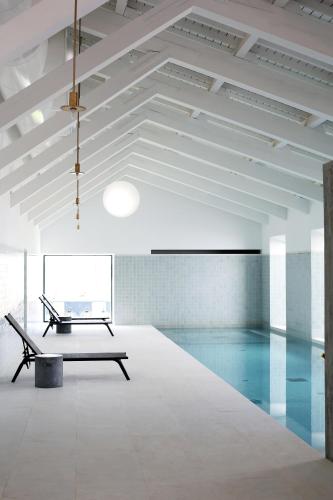 a swimming pool with a bench in a room at Torre de Palma Wine Hotel, Monforte, a Member of Design Hotels in Monforte