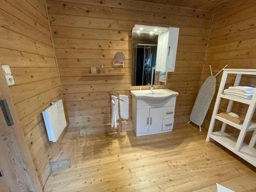 a wooden bathroom with a sink and a mirror at Waldchalet am Eichhof in Innsbruck