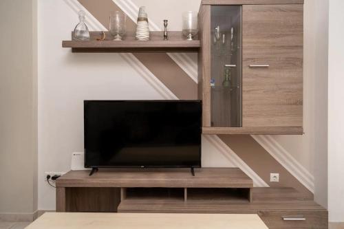 een woonkamer met een flatscreen-tv op een houten entertainmentcentrum bij Kountouriotou New Quiet and Central apartment in Athene