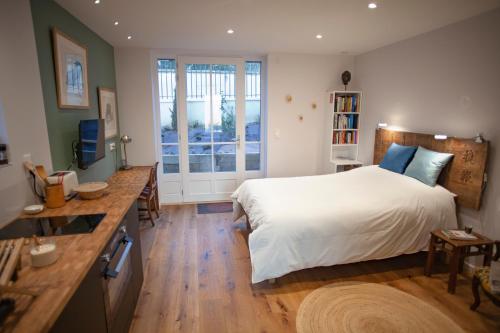 a bedroom with a large white bed and a desk at LYONEST chambre d'hôtes in Lyon