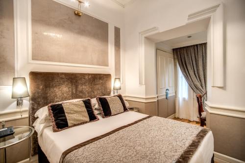 a bedroom with a large bed and a window at The Britannia Hotel in Rome