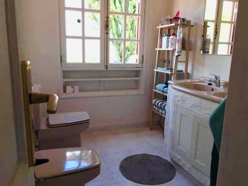 een badkamer met een wastafel, een toilet en een raam bij Paz del Mar in Charco del Palo