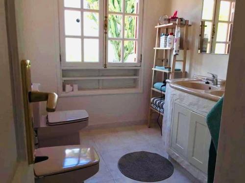 ein Badezimmer mit Waschbecken und Toilette und einem Fenster in der Unterkunft Paz del Mar in Charco del Palo