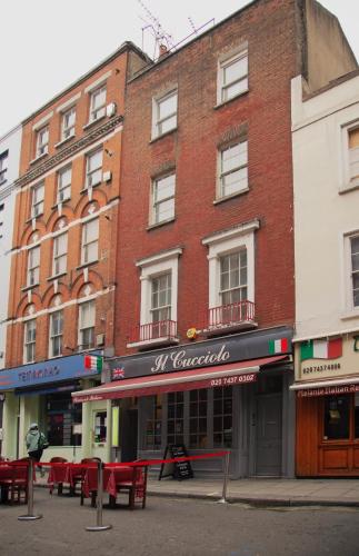 a brick building with red tables in front of it at Lovely 2 bed flat in SOHO! in London