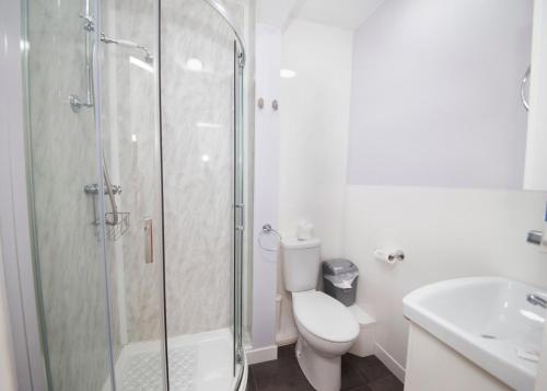 uma casa de banho com um chuveiro, um WC e um lavatório. em Midland Hotel em Weston-super-Mare