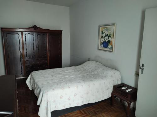 a bedroom with a bed and a wooden cabinet at Casa ótima e localização excelente em Aparecida-SP in Aparecida