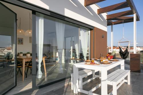 a dining room with a white table on a balcony at Sunny Penthouse in Ferrel