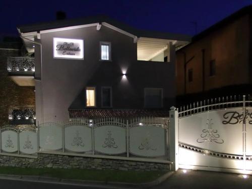 a white fence in front of a house at night at B&B Bellavista Exclusive in zona centrale con piscina riscaldata e Jacuzzi vista lago LA COLAZIONE viene servita in una pasticceria rinomata ed esclusiva esterna alla struttura in Desenzano del Garda