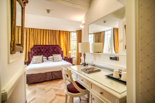 a hotel room with a bed and a desk with a desk at The Britannia Hotel in Rome