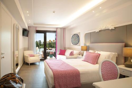 una camera d'albergo con letto e divano di Avaton Luxury Beach Resort - Relais & Chateaux a Ouranoupoli