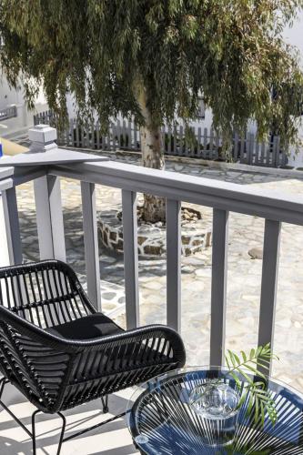a couple of chairs and a table on a balcony at Sunset Windmills Suites in Mýkonos City