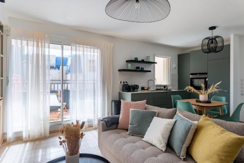 un salon avec un canapé et une cuisine dans l'établissement Cours Morny, à Deauville