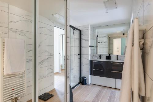 a kitchen with white walls and a glass door at Cours Morny in Deauville