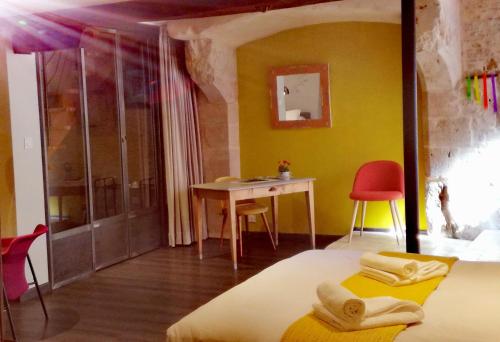 a bedroom with a bed and a table and a desk at L'antre ami in Savigny-lès-Beaune