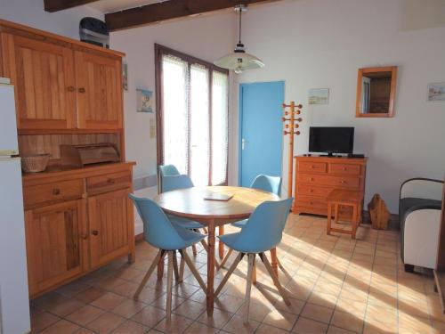 une cuisine avec une table en bois et des chaises bleues dans l'établissement Holiday Home on Oléron near Les Huttes Beach, à La Michelière