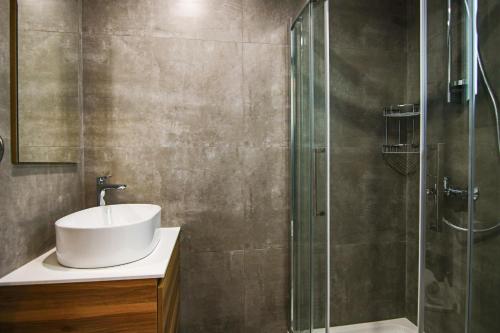 een badkamer met een wastafel en een glazen douche bij Phaedrus Living: Sea View Anna Residence 301 in Limassol
