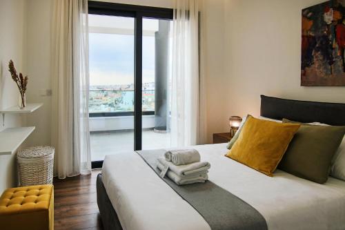 een slaapkamer met een groot bed en een groot raam bij Phaedrus Living: Sea View Anna Residence 301 in Limassol