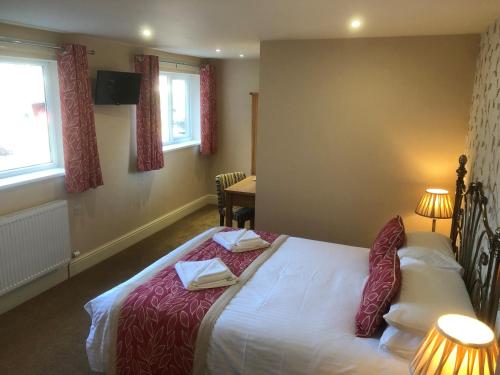 a bedroom with a bed with two towels on it at Crow Park Hotel in Keswick