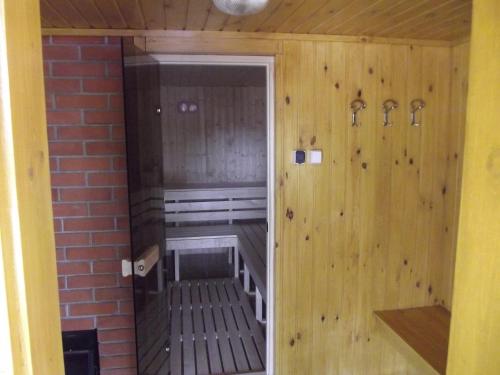 a small sauna with wooden walls and a brick wall at Hollókői Vendégház in Abaújszántó