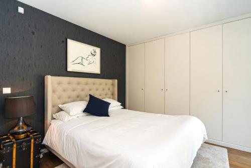 a bedroom with a white bed and a black wall at TheCalming Cactus Cascais in Estoril