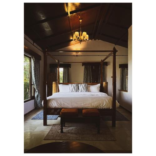 um quarto com uma cama de dossel e um lustre em Mulberry House em Almora