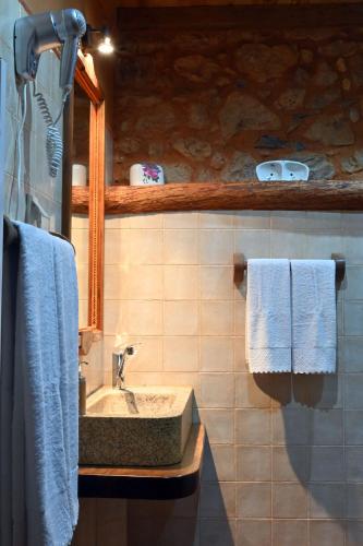 a bathroom with a sink and a mirror and towels at Casal da Serra in Penha Garcia
