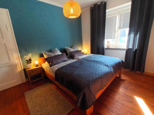 een slaapkamer met een bed en een blauwe muur bij Ferienwohnung NaumburgLiebe in Naumburg