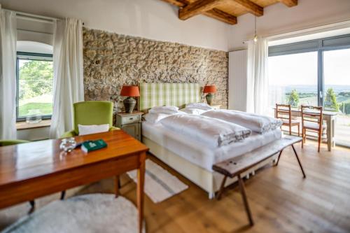 a bedroom with a large bed and a table at Winzarei Ciringa Menhard in Zgornja Kungota