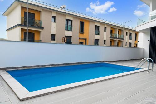 a swimming pool in front of a building at Sunny Penthouse in Ferrel