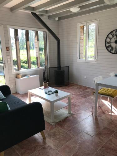 ein Wohnzimmer mit einem Tisch und einem Kamin in der Unterkunft Maison au bord de riviere , proche de la mer- spa semi rigide plein air en option in Bacqueville-en-Caux