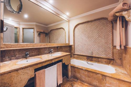 a bathroom with two sinks and a tub at JOIA El Mirador by Iberostar -Adults Only in Adeje