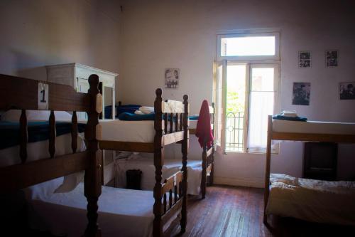 a bedroom with four bunk beds and a window at Hostel El Puesto in San Antonio de Areco