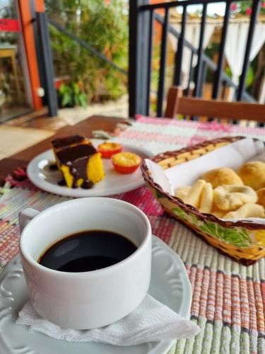 a cup of coffee and a plate of food on a table at Pousada Ikabana in Pirenópolis