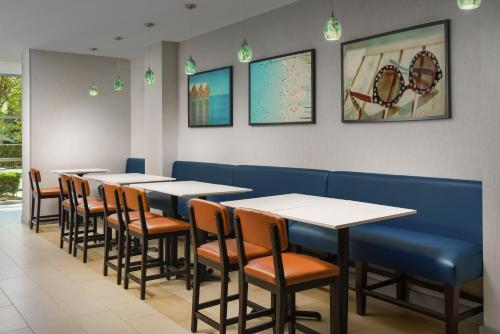 Hyatt House Fort Lauderdale Airport/Cruise Port في دانيا بيتش: صف من الطاولات والكراسي في مطعم