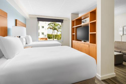 um quarto de hotel com uma cama e uma televisão em Hyatt House Fort Lauderdale Airport/Cruise Port em Dania Beach