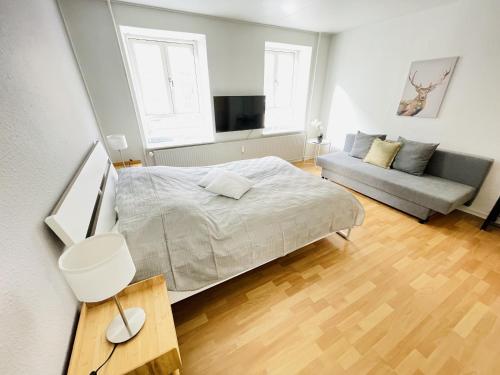a bedroom with a bed and a couch at aday - Central Studio Apartment in Aalborg