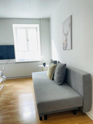 a living room with a couch and a window at aday - Central Studio Apartment in Aalborg