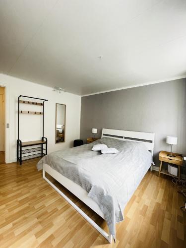 a bedroom with a large white bed and wooden floors at aday - Central Studio Apartment in Aalborg